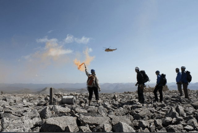 Moutain Rescue Team Guides in a Rescue Helicopter with a Smoke Marker